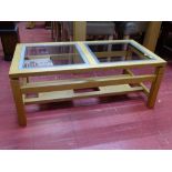 Modern light wood coffee table with twin glass inserts and having a lower base shelf