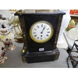 An ornamental slate mantel clock with enameled dial