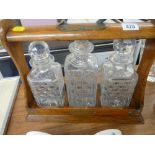 Victorian oak three bottle tantalus with key (bottles not matching)