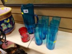 Blue glass seven piece water set and a cranberry glass floral decorated jug