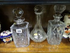 Two square pressed glass whisky decanters and a narrow necked decanter