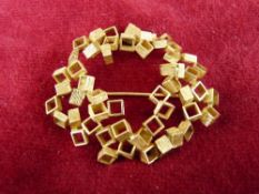 AN UNTESTED GOLD COLOUR CUBIST FORM BROOCH in the manner of John Donald (unmarked), 5 cms across, 16