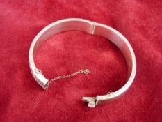 A SILVER HALF BRIGHT CUT BANGLE with safety chain, 22.8 grms