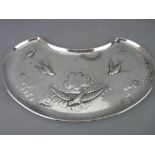 A KIDNEY SHAPED TRAY with an embossed pattern of a sunburst and birds flying amongst clouds,