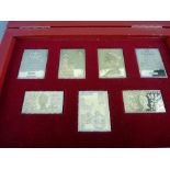 A CASED SET OF SEVEN SILVER GILT COMMEMORATIVE STAMPS by hallmark replicas commemorating the 25th