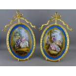 A PAIR OF SEVRES STYLE PLAQUES in gilded ormolu mounts, impressed 230 to the backs, the mounts