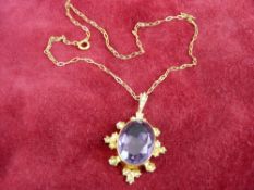 A FIFTEEN CARAT GOLD OVAL AMETHYST PENDANT surrounded by seed pearl encrusted leaves and with