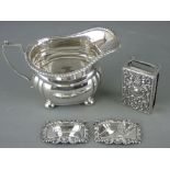 FOUR ITEMS OF SMALL SILVER to include a cream jug on ball feet, an embossed matchbox holder and