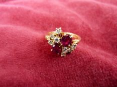 AN EIGHTEEN CARAT GOLD TWO RUBIES & EIGHT SMALL DIAMONDS RING, 4.7 grms, size 'P/Q'