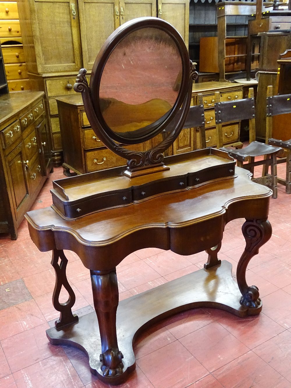 A VICTORIAN MAHOGANY DUCHESS DRESSING TABLE having an oval mirror on carved support above a bank