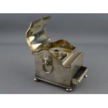 AN ELECTROPLATED SINGLE BOTTLE DESK STAND of casket form with shaped lid and pen aperture, lion mask