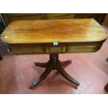 A REGENCY MAHOGANY FOLDOVER CARD TABLE with baize lined interior and swivel top on a turned column