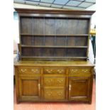 AN EARLY 19th CENTURY OAK DRESSER of joined construction with wide boarded three shelf rack over a