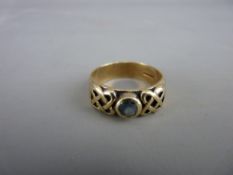 A NINE CARAT GOLD CELTIC RING with small topaz centre stone