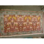 AN EXCELLENT INDIAN SILKWORK RUG, red ground with a repeating pattern of wild beasts, animals and