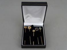 FIVE VINTAGE STICK PINS, most unmarked including two knot examples, one with garnet centre, a