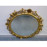 A VINTAGE CARVED GILT WOOD & GESSO FRAMED CIRCULAR WALL MIRROR with pierced foliate design (some