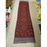 A MESHWANI CARPET RUNNER, red ground with repeating central diamond pattern and continuous border,