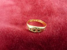 A TWENTY TWO CARAT GOLD LADY'S DRESS RING with three tiny rubies (one missing), 2 grms