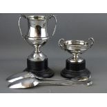 A GEORGE III SILVER SERVING SPOON & ONE OTHER with two silver twin handled trophies on stands,