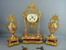 AN EMPIRE STYLE GILT METAL & PINK MARBLE CLOCK GARNITURE on gilt wood stands having a drum cased