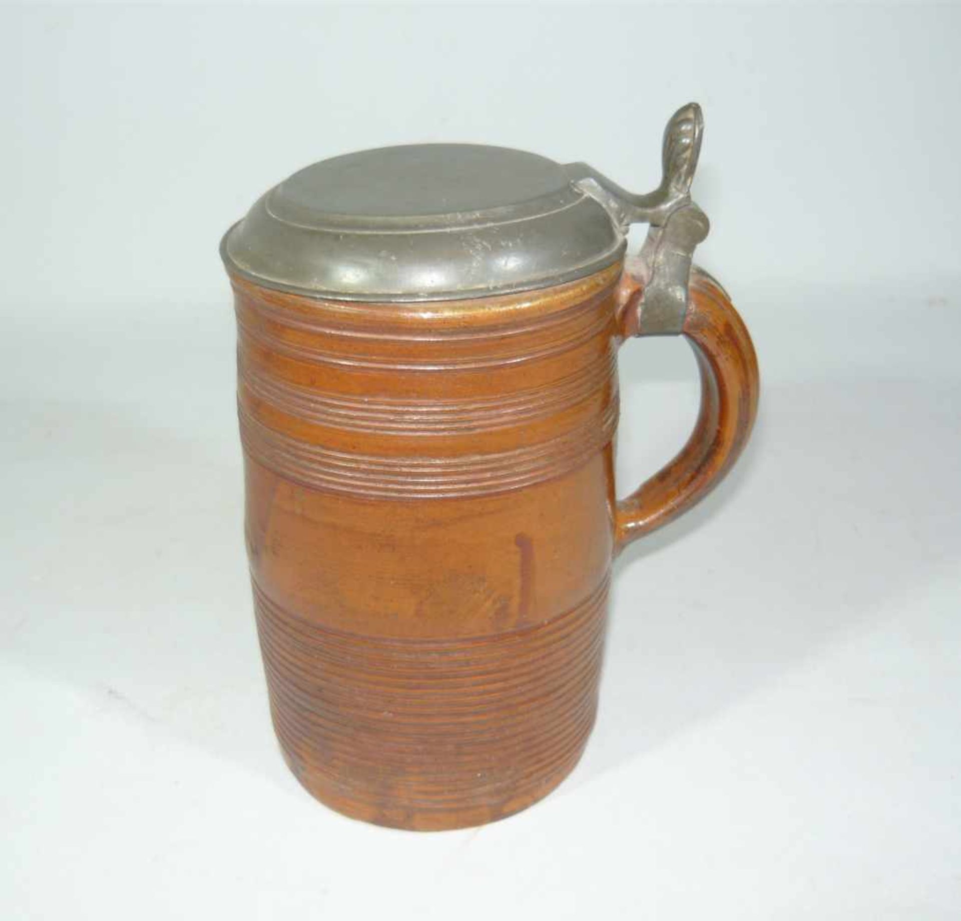 Großer Walzenkrug mit Zinndeckel. Wohl um 1700. H. ca. 21 cm. Altersspuren.Large cylinder-mug with