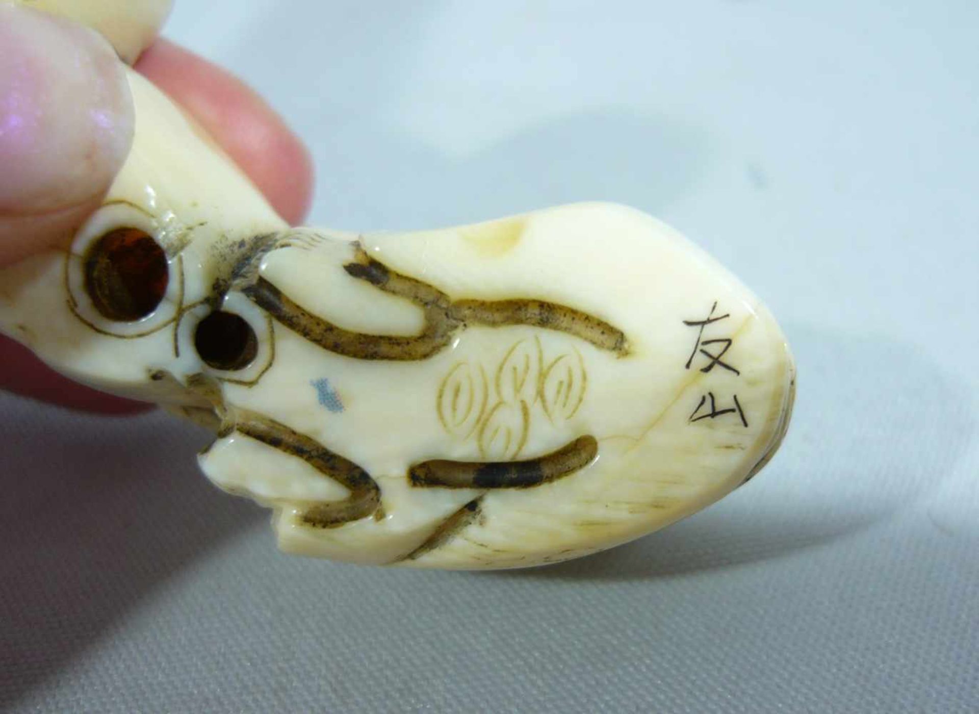 Netsuke. Figur, die zwei große Köpfe vor sich herschiebt. Elfenbein, handgeschnitzt. China o. Japan, - Bild 2 aus 2