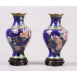 Paar Cloisonné-Vasen.China, nach 1900. Balusterform. Holzsockel. H: 23,5 cm. 20.00 % buyer's premium