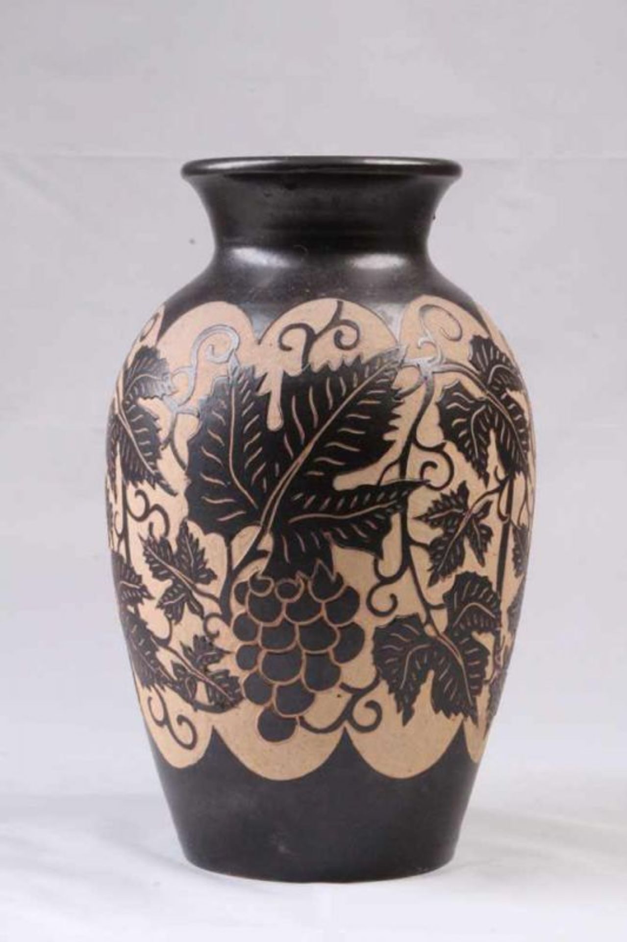 Keramikvase.Anthrazitfarbene Glasur. Geätzter Dekor von Weinlaub und Trauben. H: 33 cm. 20.00 %