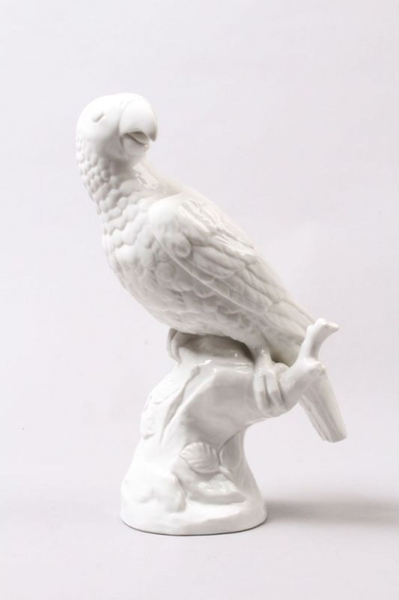 Porzellanfigur.Nymphenburg, 20. Jh. Papagei. Weiß glasiert. H: 35 cm. ( Abplatzung 1x1 cm.) Grüne