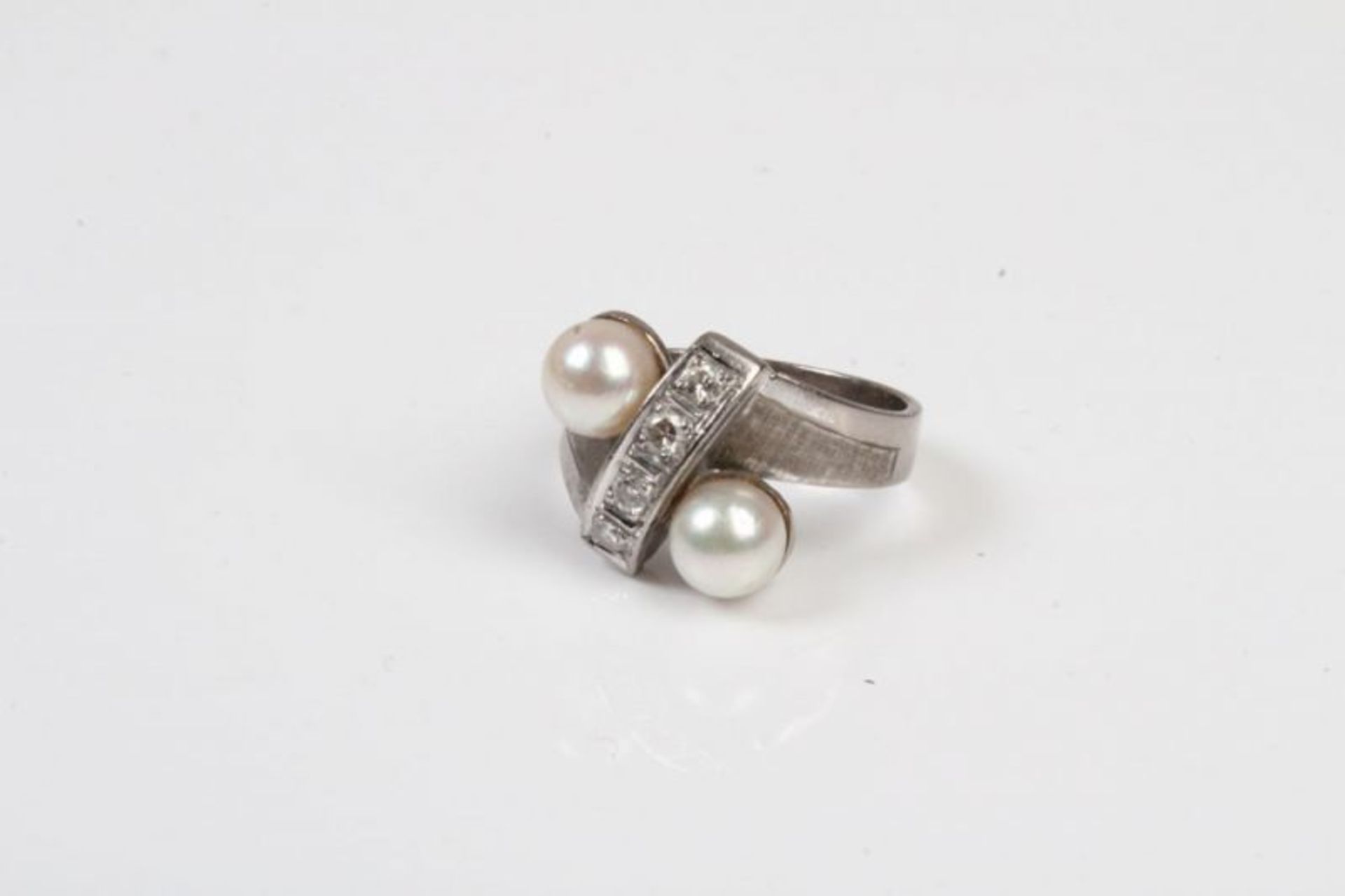 Damenring.WG 585. Breite Schiene, Ringkopf mit versetzten Perlen, dazwischen Brillanten. Gew. ca.