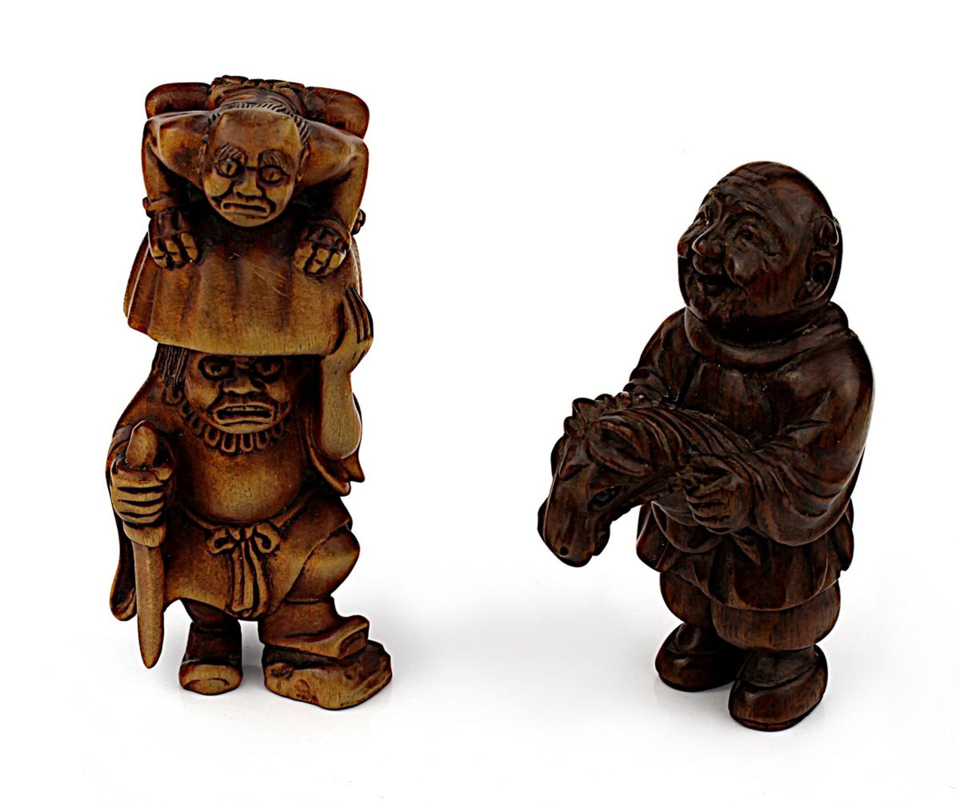 Zwei Netsuke, groteske Figuren, Holz, Japan 1. Hälfte 20. Jh., eine männliche Figur mit Steckenpferd