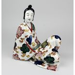 Japanische Porzellanfigur wohl der späten Edo-Zeit, Ruhender junger Mann im Kimono, Porzellan heller