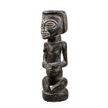 Weibliche Ahnenfigur der Kuba, D. R. Kongo, auf flachem Sockel sitzende Figur mit vor dem Bauch