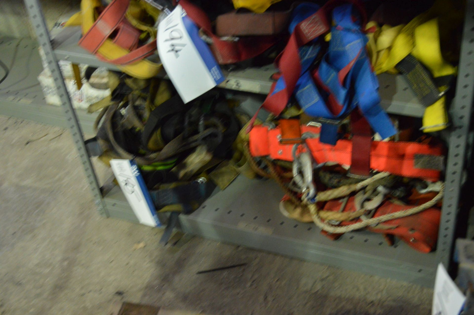 Assorted safety Harnesses, on one shelf of rack