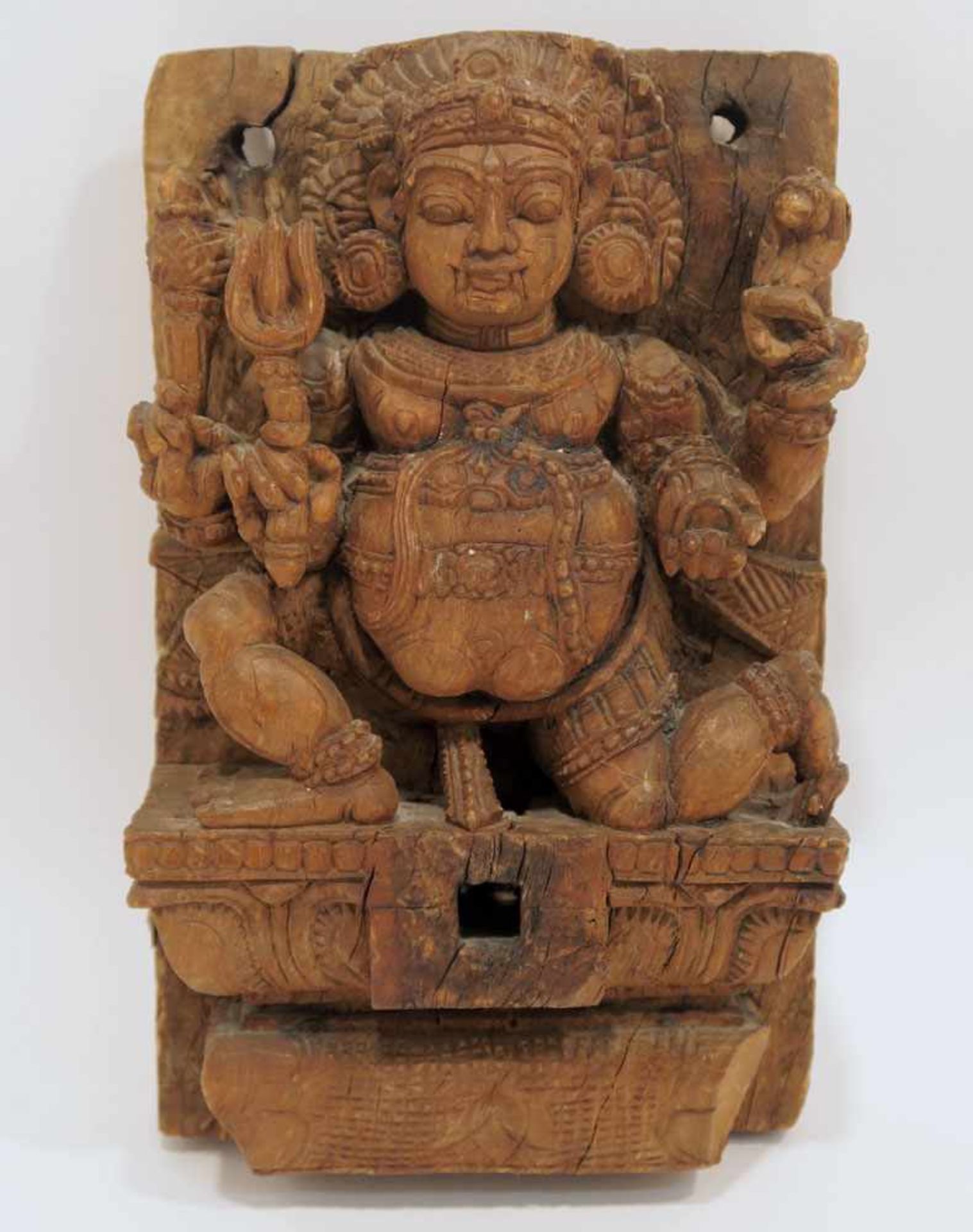 Reliefschnitzerei: vierarmige Gottheit mit Dreizack Indien (?). Holz, geschnitzt, ungefasst.