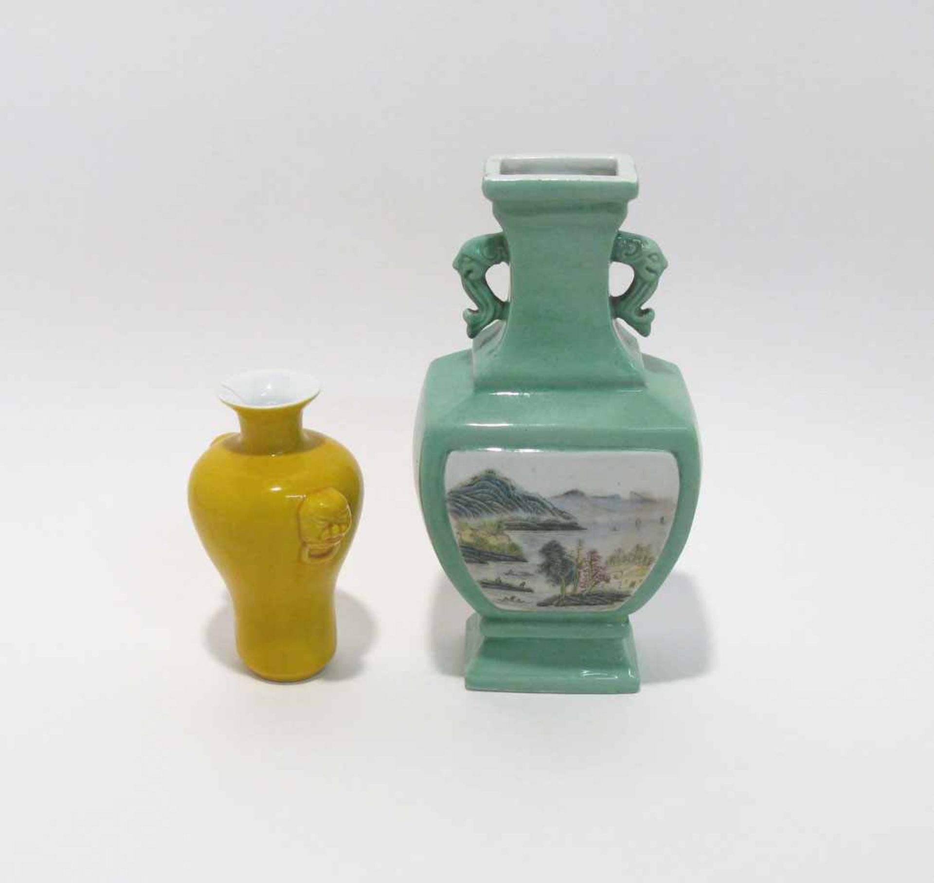 Zwei Vasen China. Porzellan. Jeweils mit Tierkopfgriffen. Gelber Fond bzw. grün mit polychromen