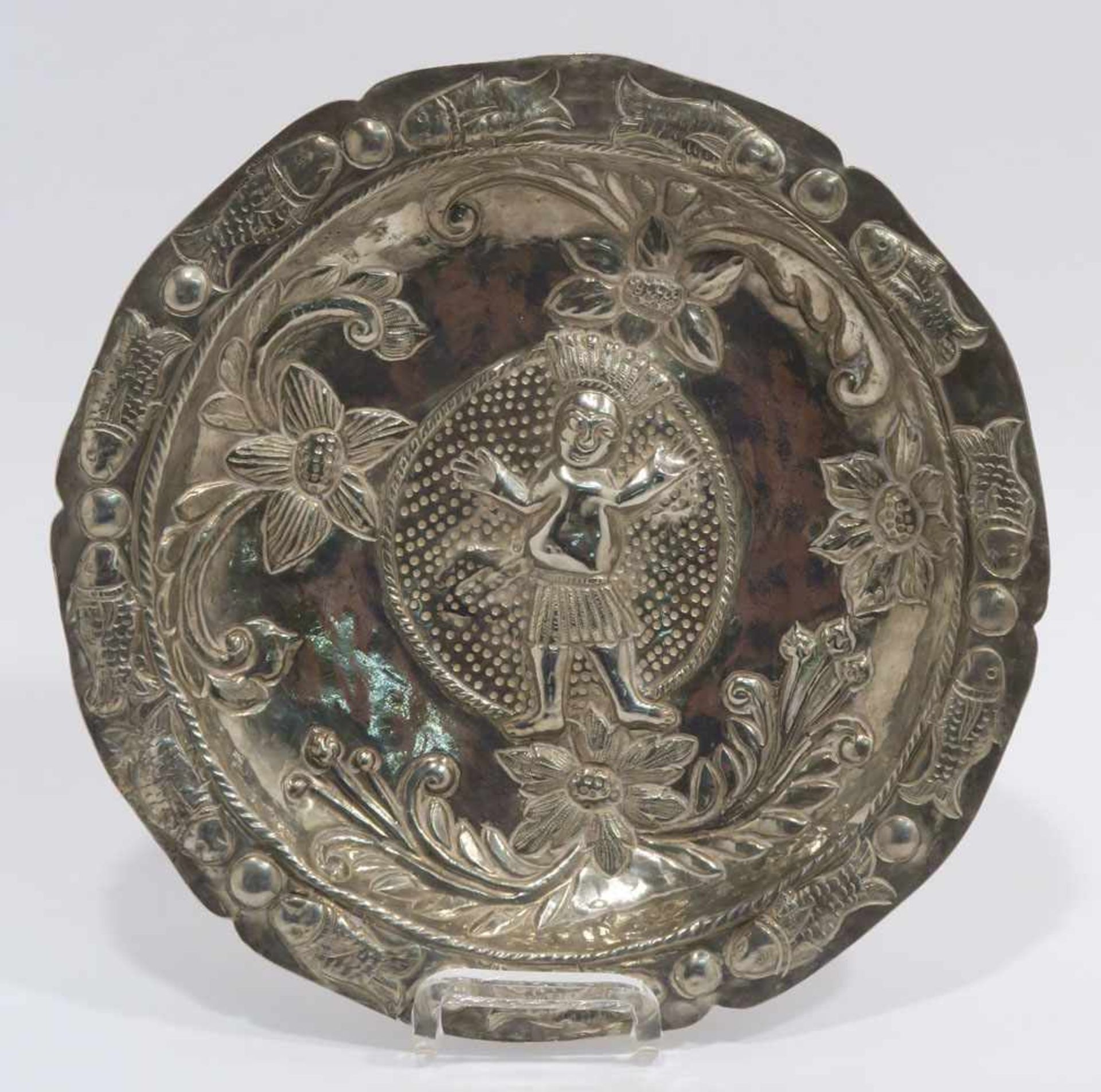 TellerWohl Südamerika. Silber. Reliefdekor: indigener Mann, Blumen, Fische. Ø 21 cm. 260 g.
