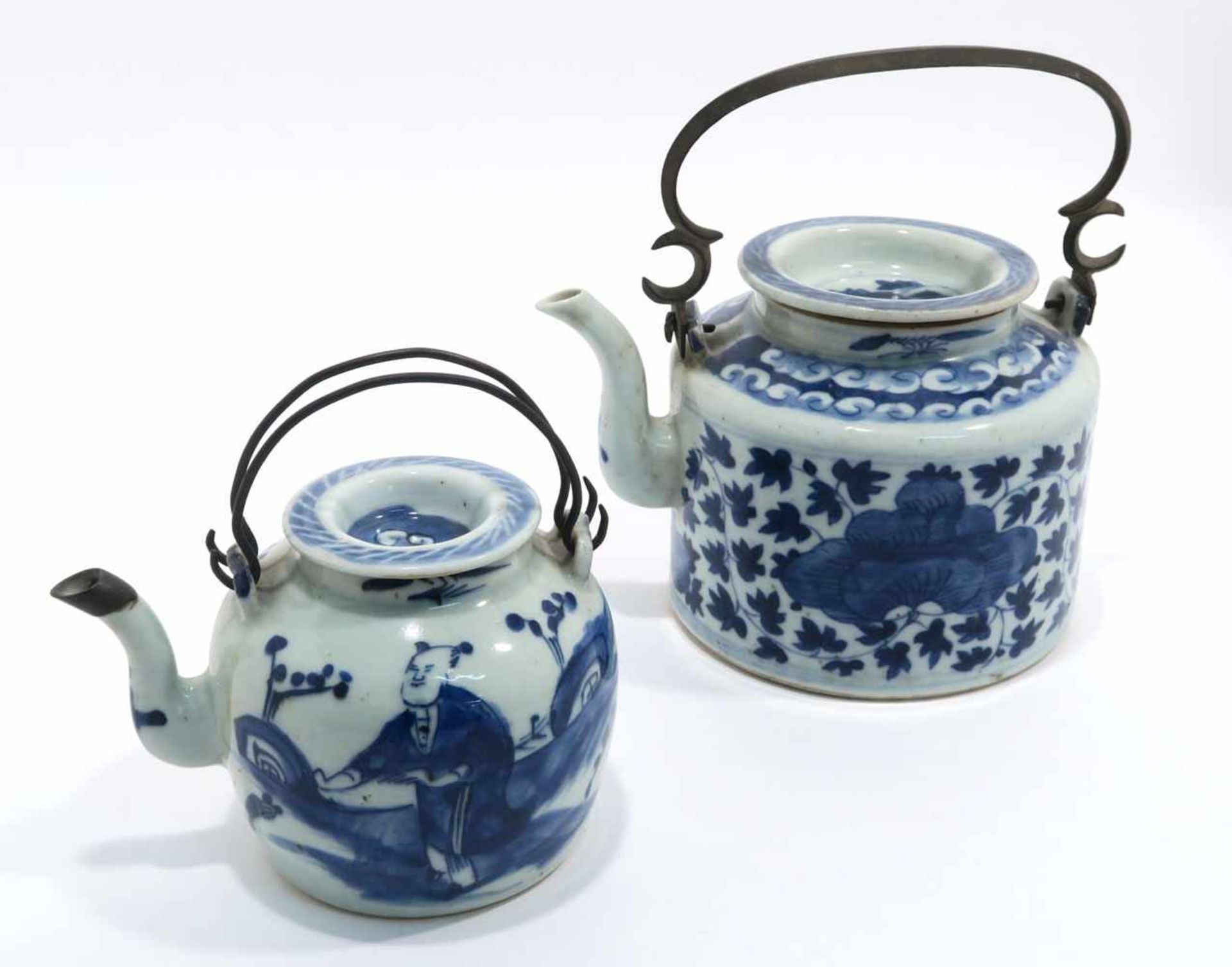 Zwei TeekannenChina. Porzellan. Floraler bzw. figürlicher Blaudekor. Metallhenkel. H. 11,5 cm bzw.