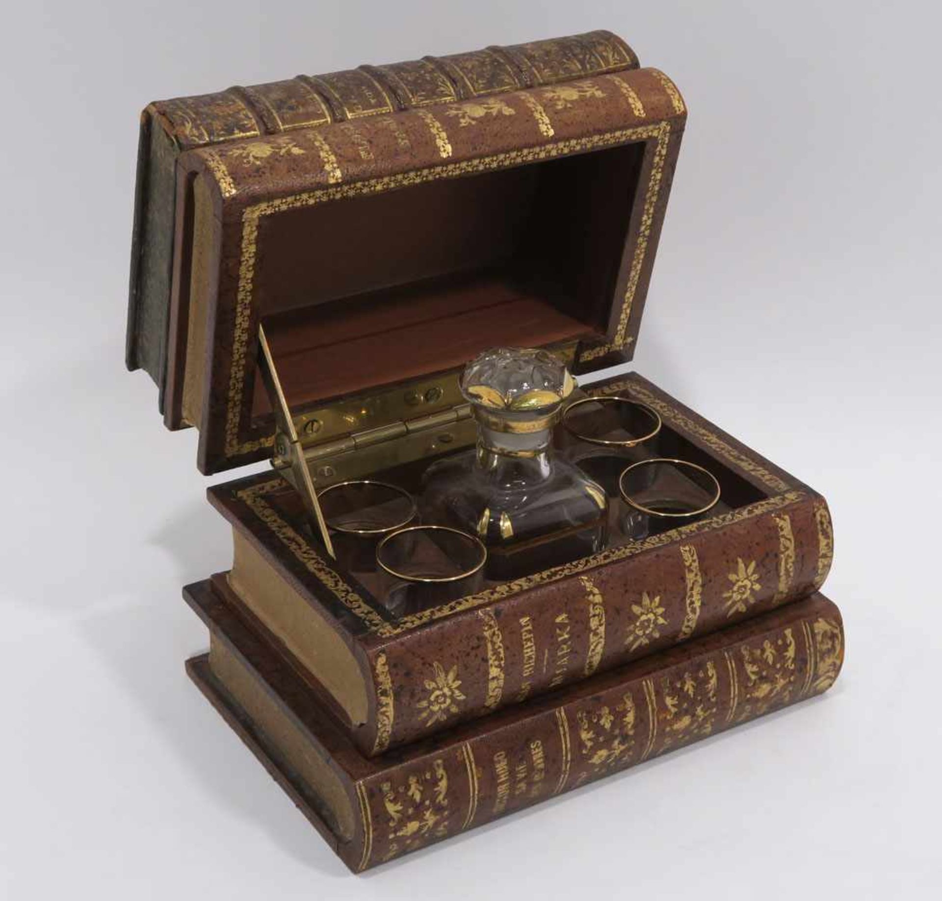 Schatulle mit LikörserviceSchatulle in Form eines Bücherstapels mit Ledereinbänden. Innen kleine