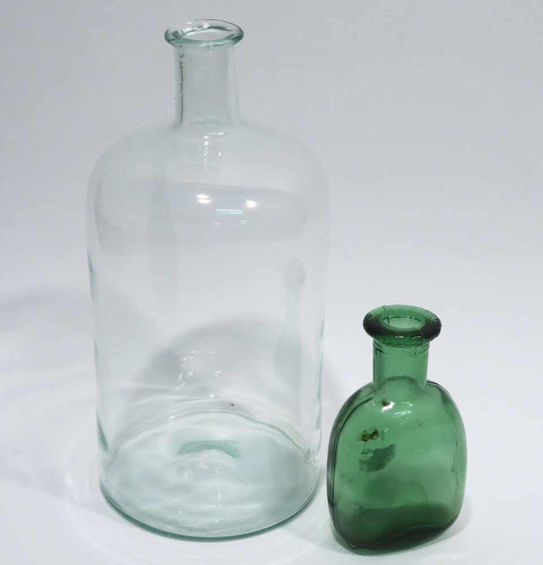 Zwei Flaschen19./20. Jh. Grünstichiges bzw. grünes Glas. H. 24 cm und 11,5 cm.