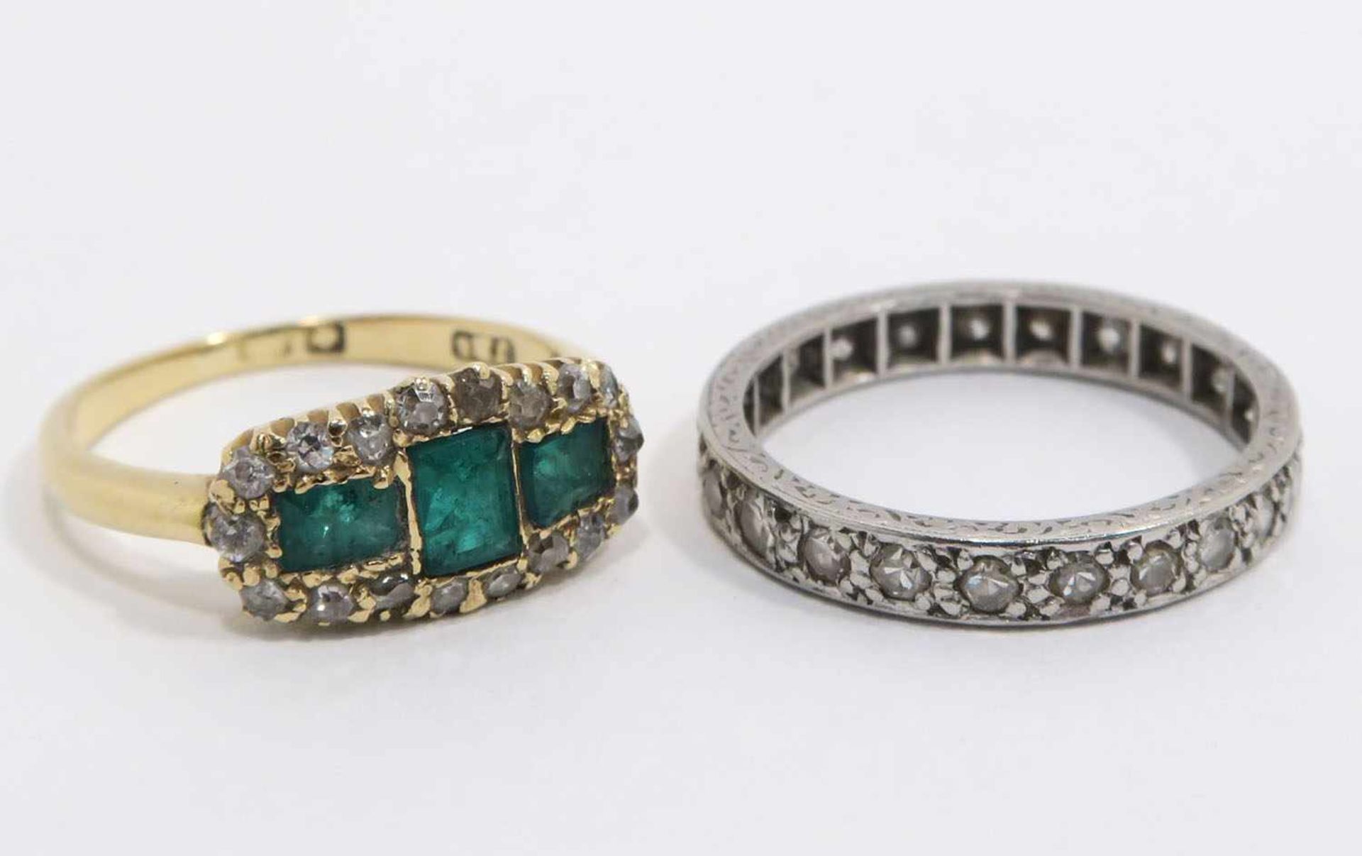 Zwei Ringe18 K GG, Marken bzw. 18 K WG. Mit drei Smaragden und Diamantsplitter bzw.