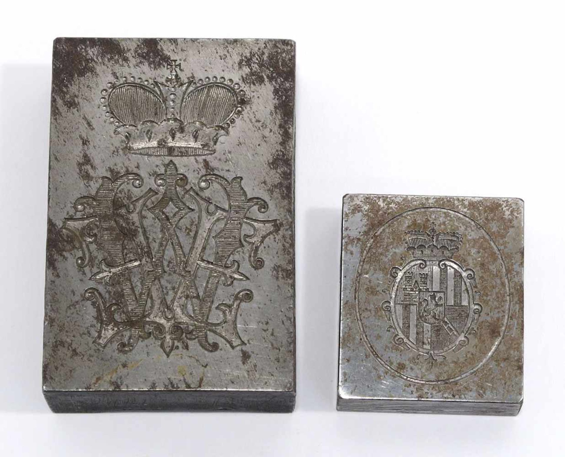 Zwei PetschafteEisen. Quadratisch, mit Wappen bzw. bekröntem Monogramm. 1 x 3 x 3,5 cm bzw. 1,6 x