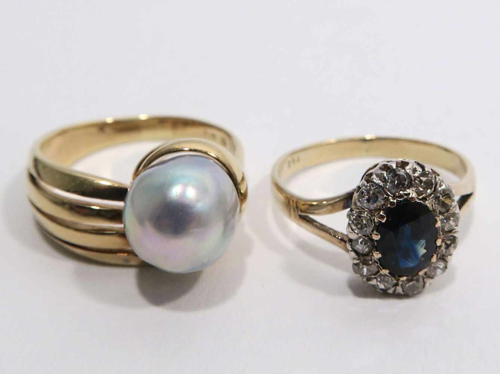 Zwei Ringe14 K GG, Marken (585). Mit einem Saphir, umgeben von Diamantrosen bzw. einer Perle