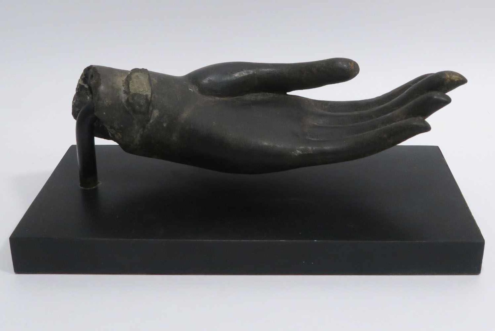 Linke Hand eines BuddhasThailand, Sukhothai-Stil. Bronze mit Tonkern. L. 21,5 cm. Holzsockel. Lt.