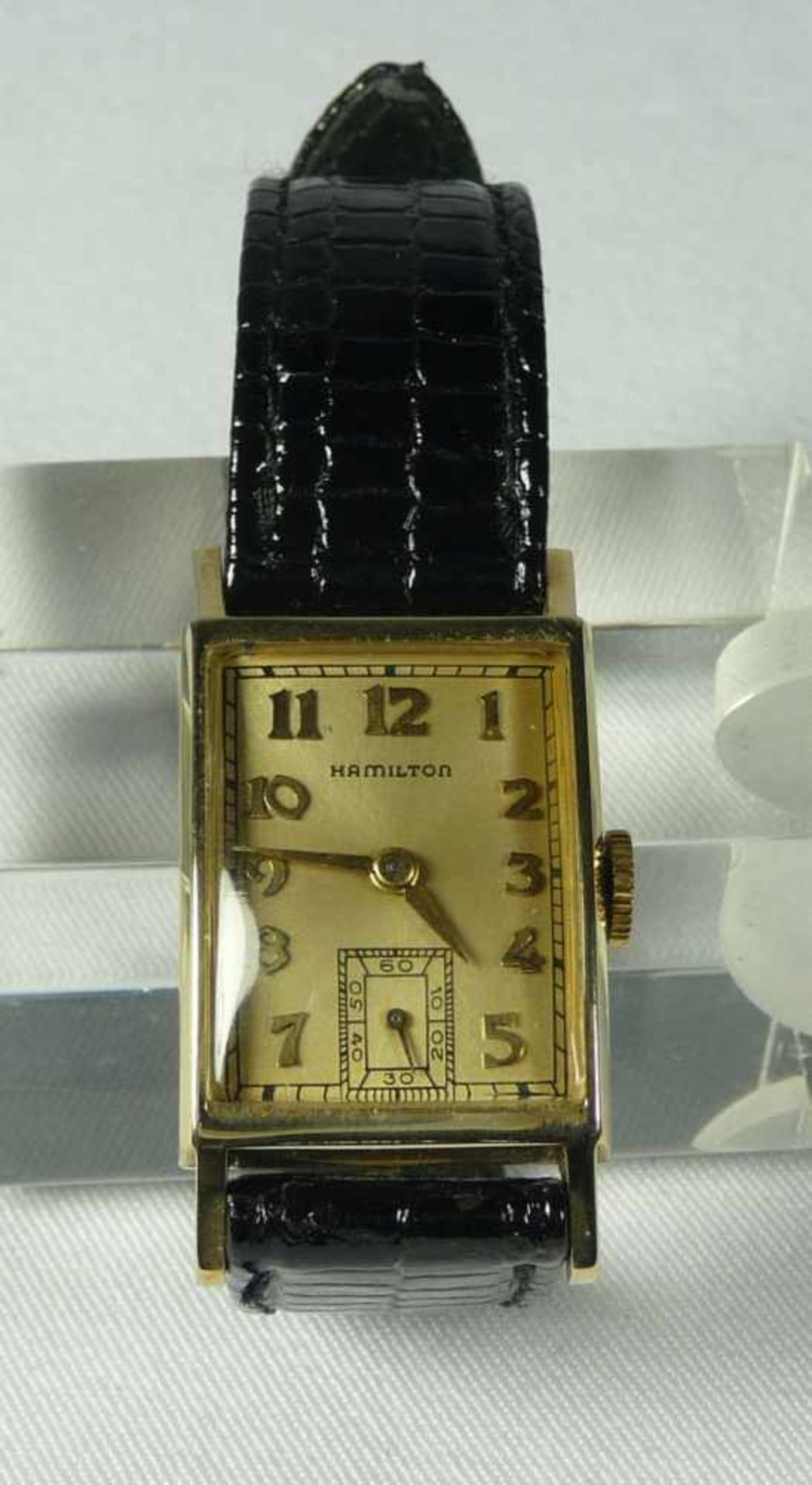 Hamilton-DamenarmbanduhrUSA, 1940er JahreHochrechteckiges Gehäuse, goldfarbenes Zifferblatt mit