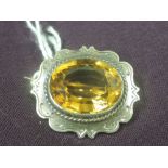 A small yellow metal brooch having a citrine stone