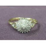 A lady's dress ring having a triple diamond chip stepped cluster to open shoulders on a 9ct gold