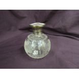 A glass perfume bottle of spherical form having cut floral decoration and HM silver lid