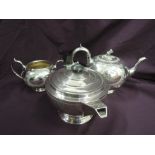 A silver plated teapot and sugar bowl and another teapot in the Art Deco style